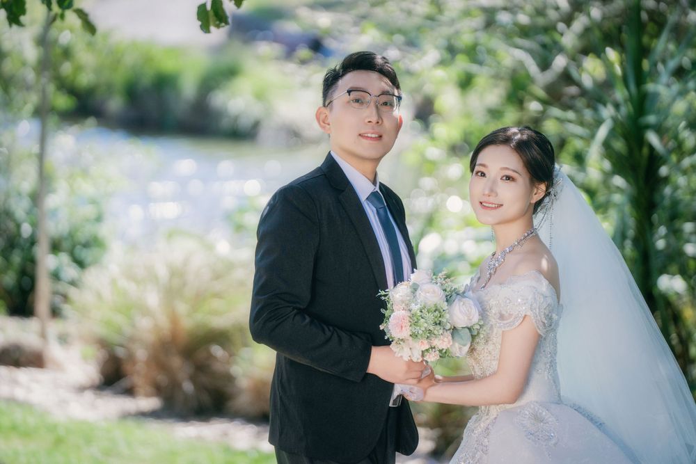 Stunning and happy couple enjoying afternoon sunlight in a natural botanical garden wedding portrait, by Imagine Image Studio Auckland.