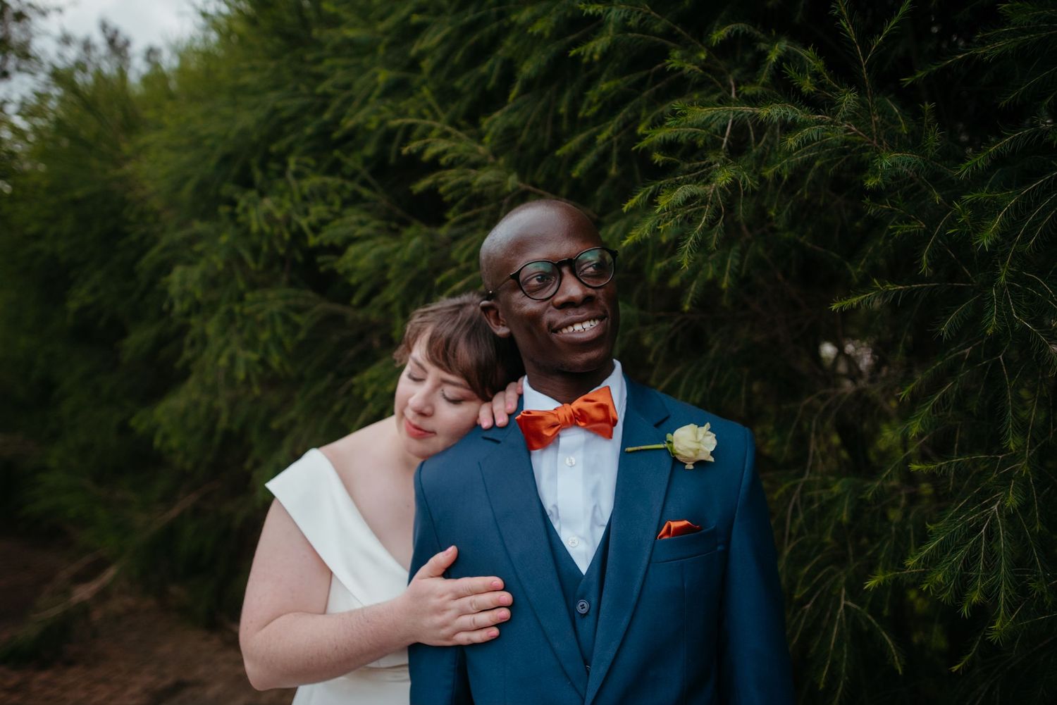 Wedding couple shares intimate moments in a lush garden setting.