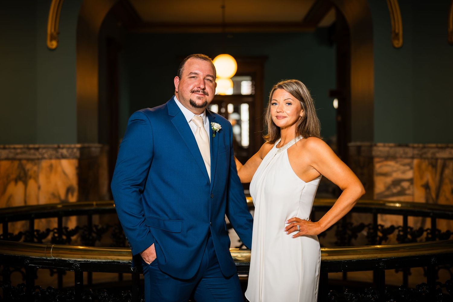 A joyful wedding couple sharing a laugh during golden hour portraits.