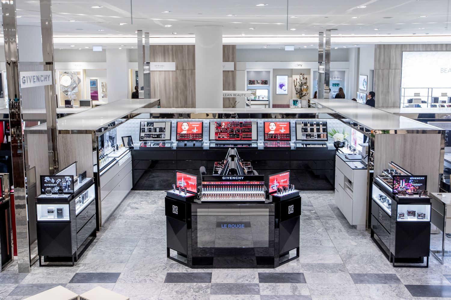 Retail electronics display area with digital screens and counter displays in modern store.