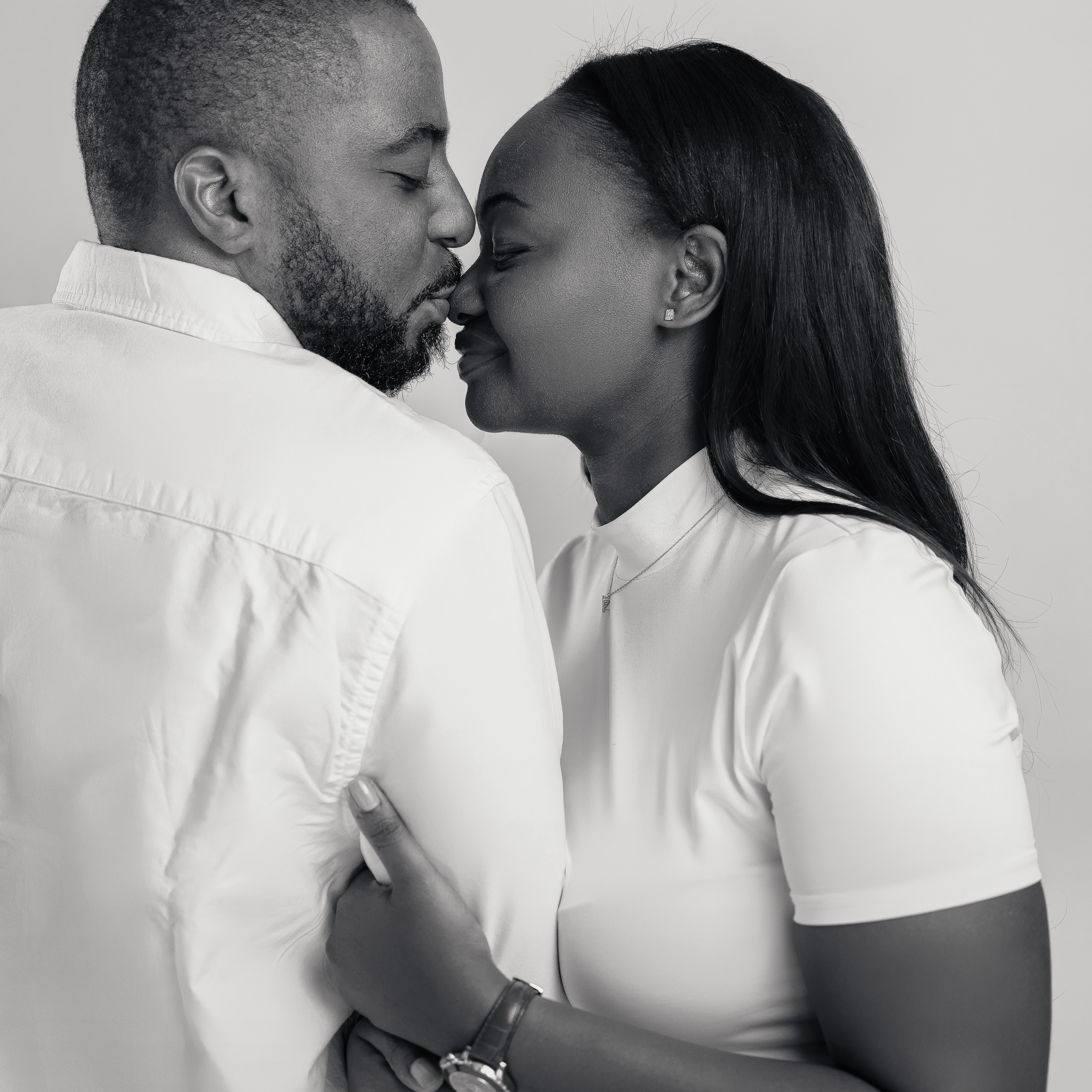 Intimate black and white portrait of a couple sharing a romantic moment.