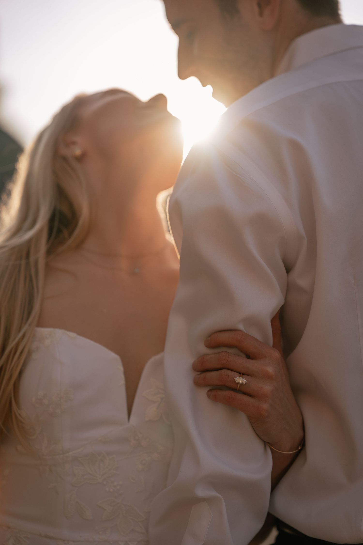 Close-up of hands wearing elegant engagement ring with delicate lighting and soft focus.