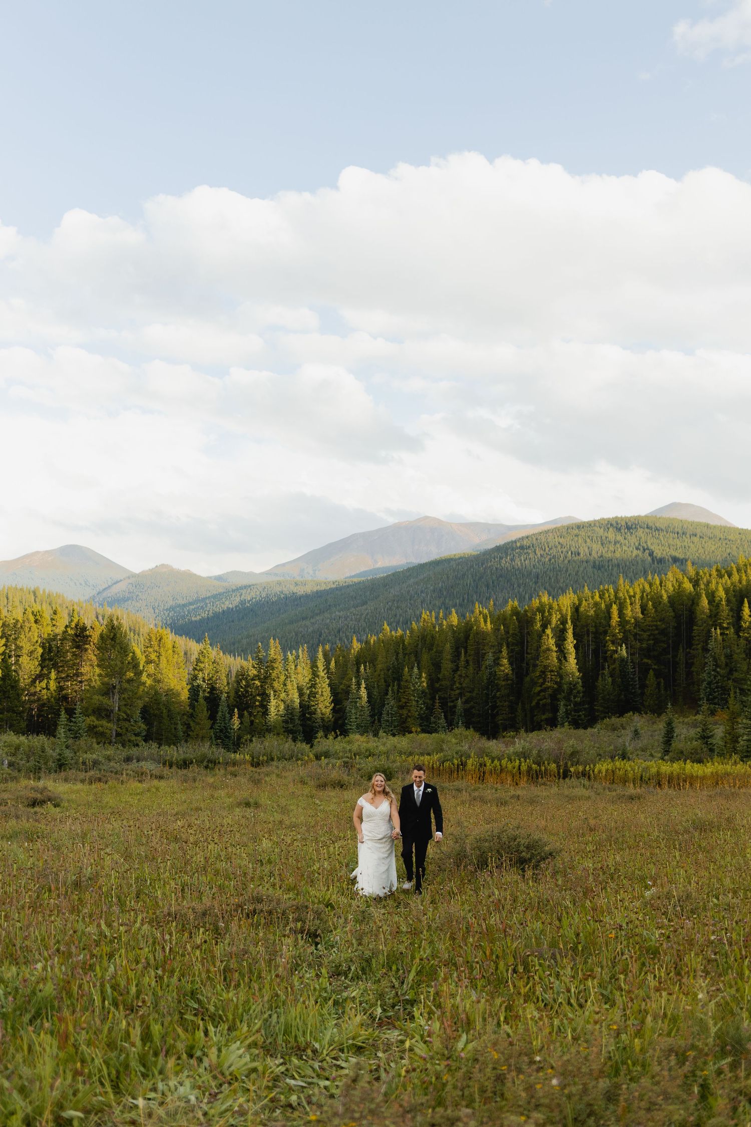 Couple walking hand-in-hand through a wildflower meadow, capturing the natural beauty of a Breckenridge elopement