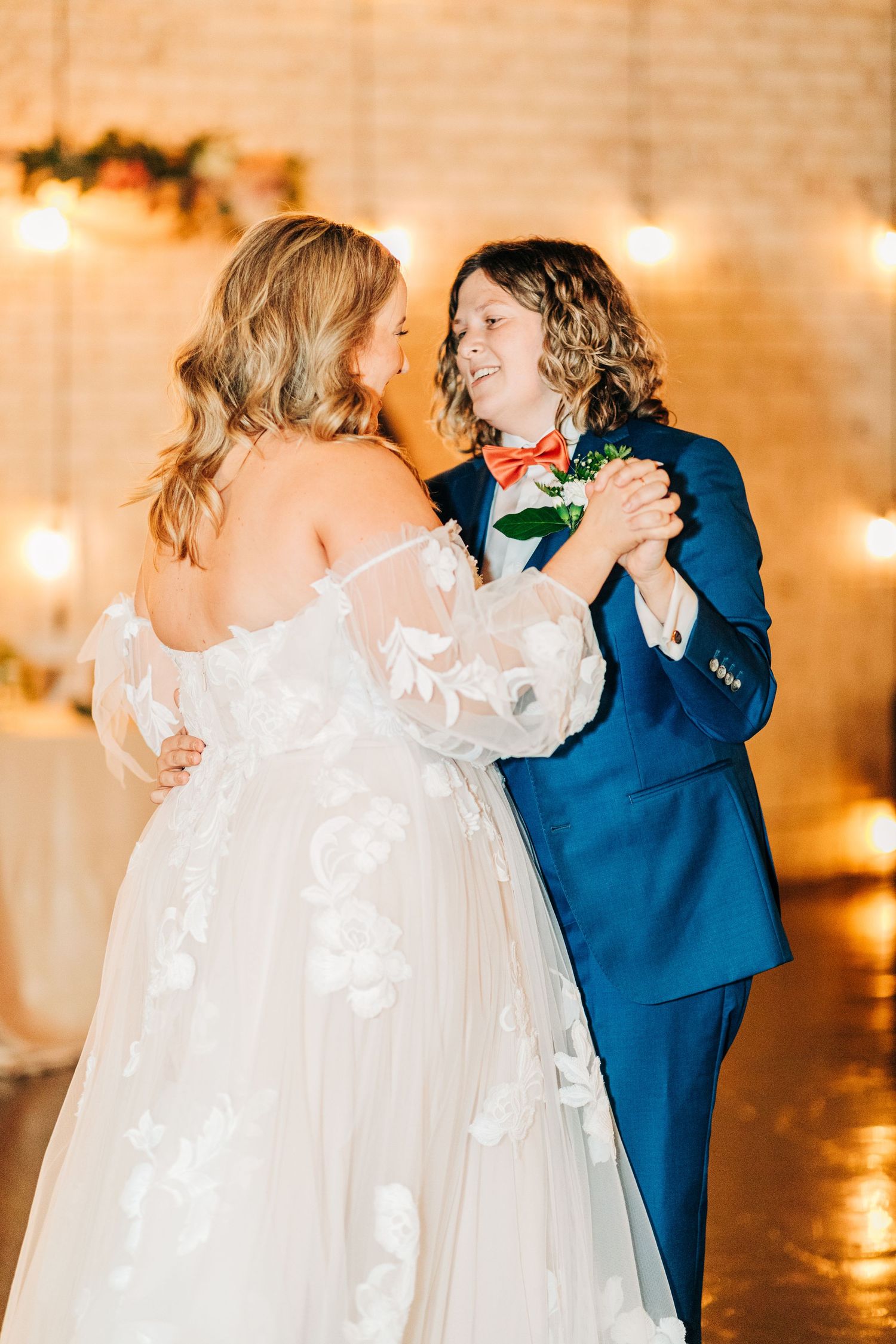 Couple sharing intimate dance moment at wedding reception with twinkle lights.