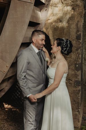 Intimate wedding portrait showing tender moment beneath industrial architecture.