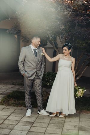 A playful wedding photo session in a garden setting with casual sneakers.