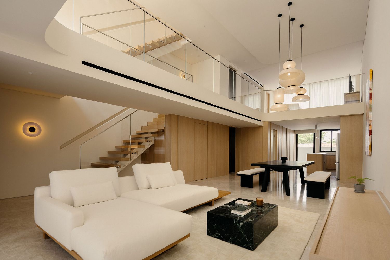Contemporary living room with dramatic lighting, white sofa, and dark wood panel wall features.
