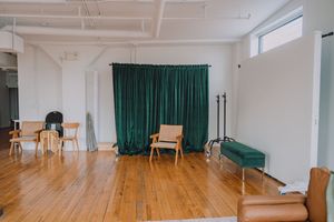 Empty dance studio with wooden floors, white walls, and green curtains shown from multiple angles.