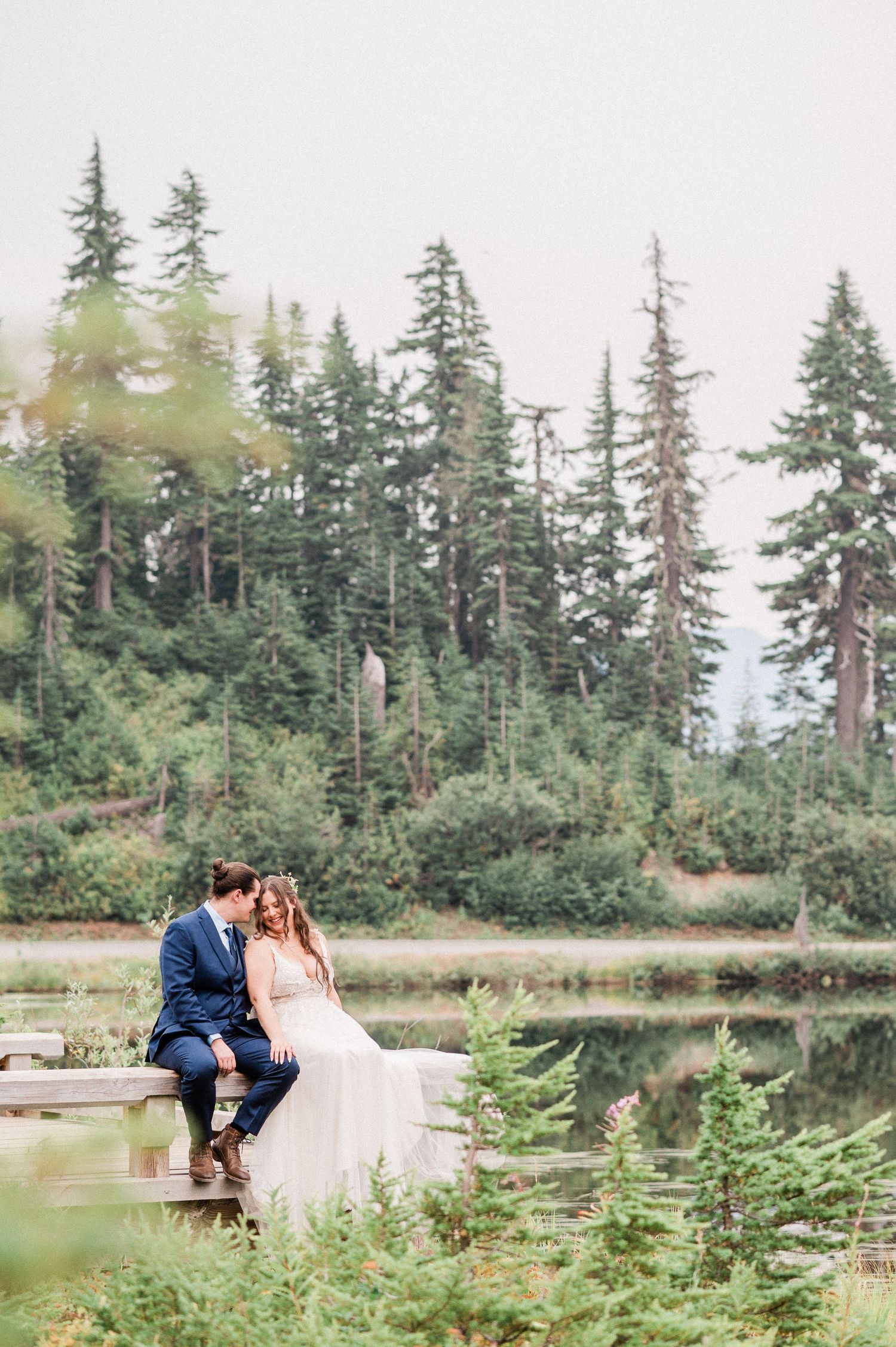 bride and groom sitting by Picture Lake during their Washington elopement. Photo by Pine + Vow
