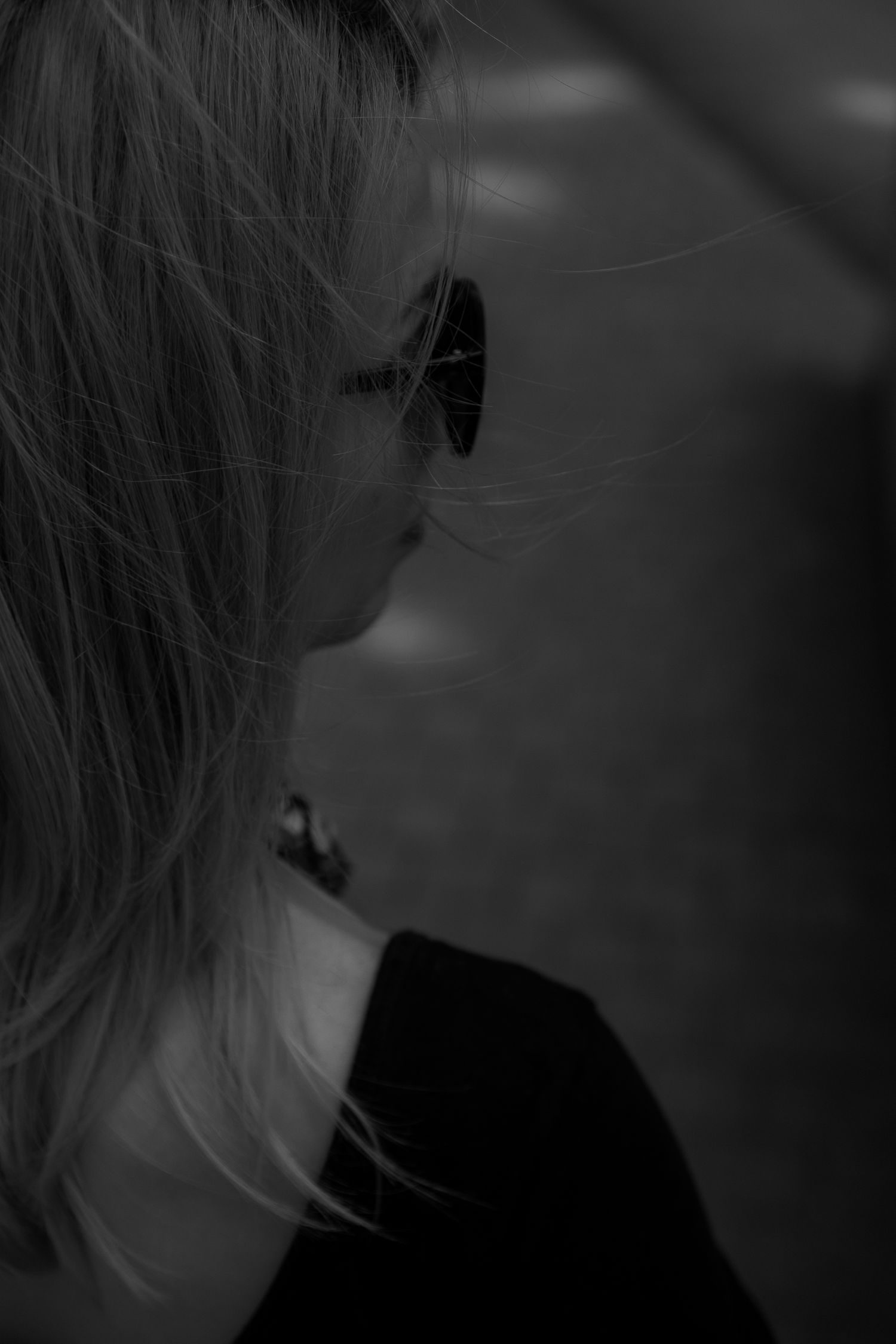 Artistic side profile shot in dark lighting showing hair detail.