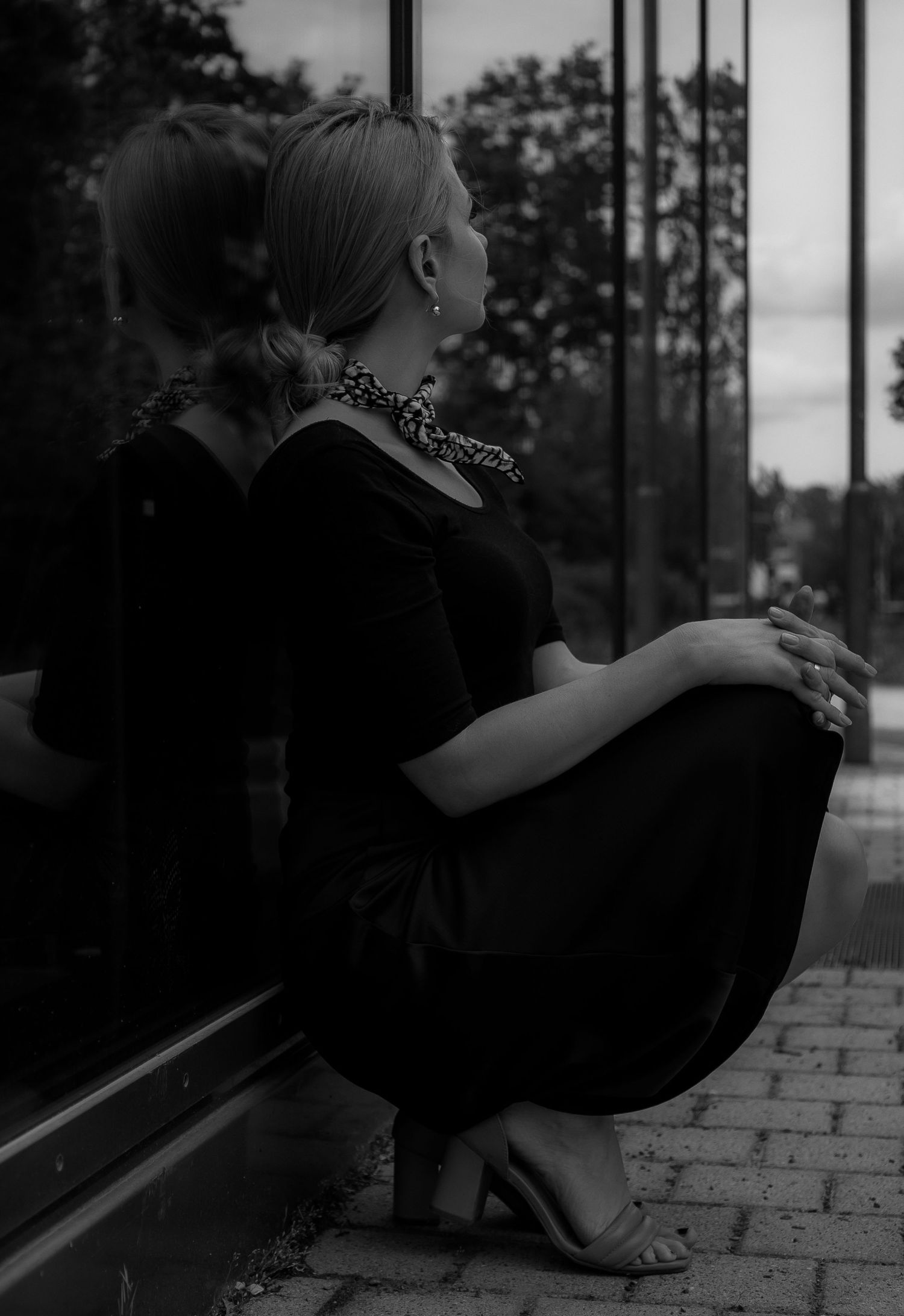 Moody black and white portrait in classic dress with patterned scarf.