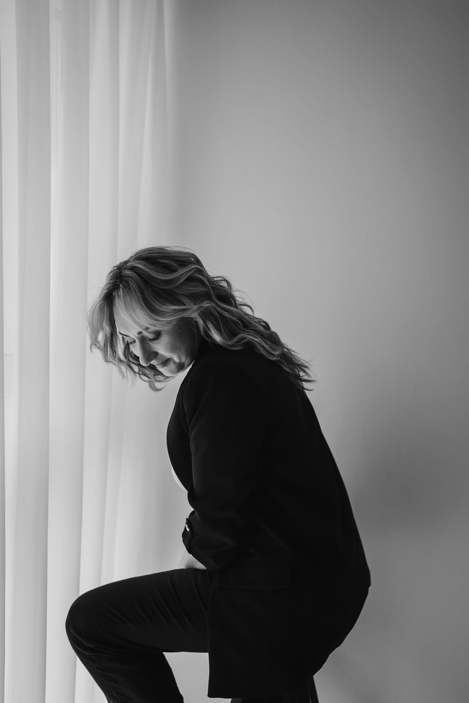 A black and white sequence showing a figure in dark clothing moving and turning against a stark light backdrop.