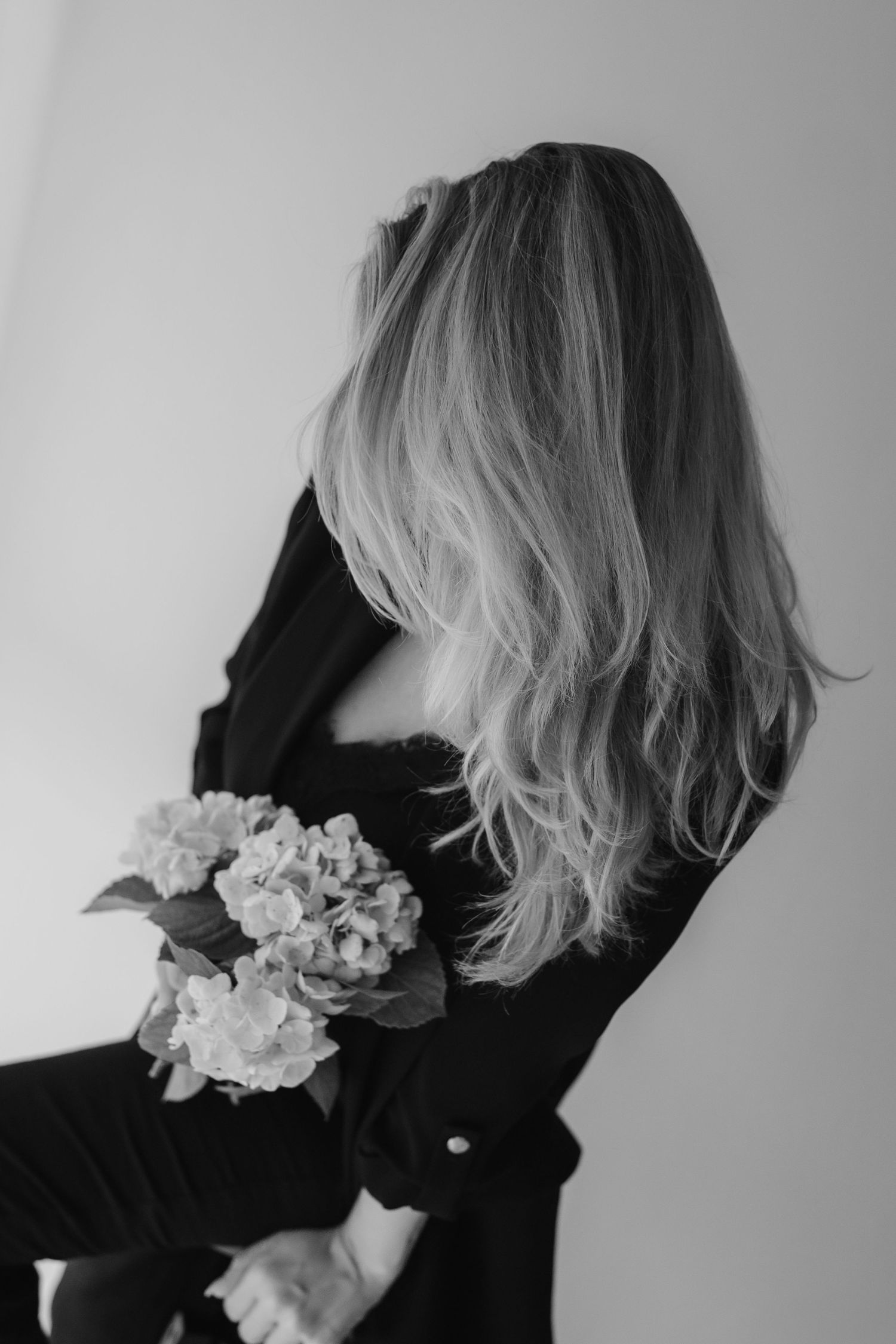 A series of black and white artistic profile silhouettes featuring blonde hair adorned with delicate white flowers.