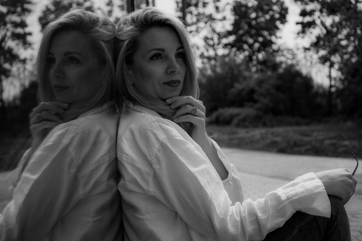 Black and white portrait with mirror reflection creating a dramatic double image.