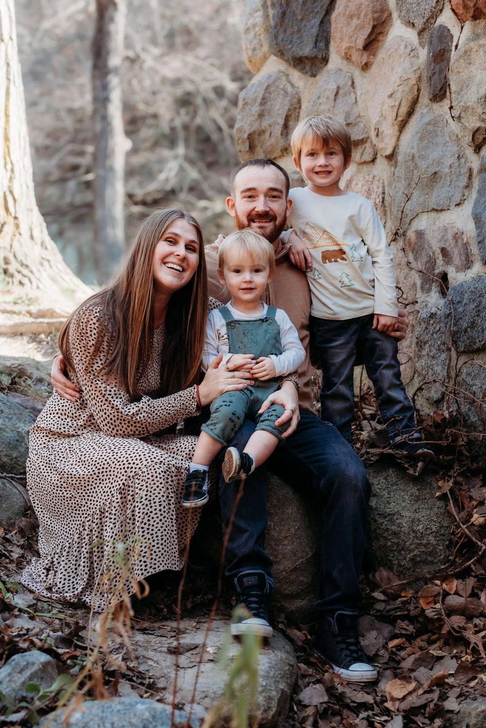 Iowa midwest family photography in ledges state park boone iowa. Natural light image of family of 4 sitting on rocks beside stone bridge