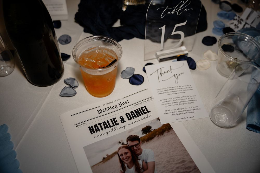 Wedding reception table with a beer, table number 15, thank you card, and a wedding post program for Natalie and Daniel.