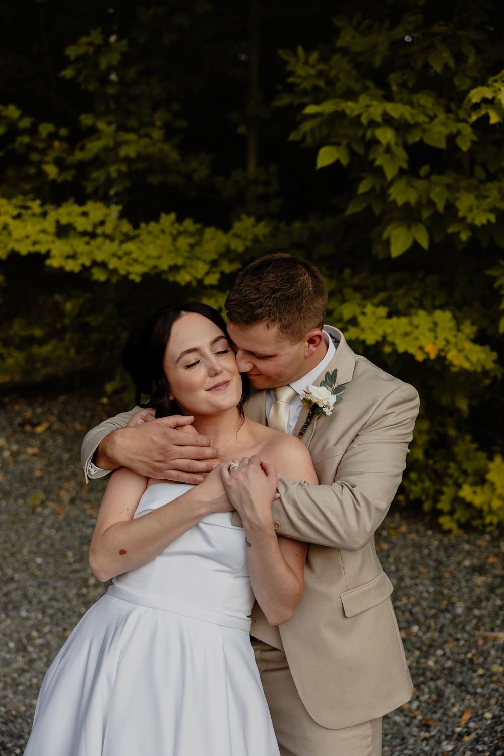 A romantic wedding couple shares intimate kisses in a series of photos with autumn foliage in the background.