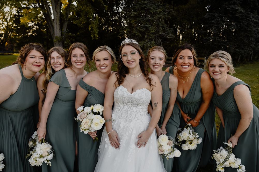 Bridesmaids in sage green dresses pose with bouquets during an outdoor wedding in Sheboygan, WI  with Essence Rose Photography.