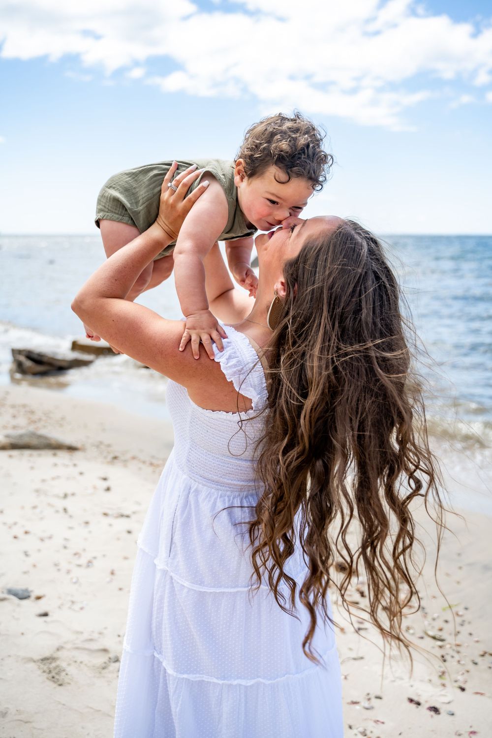 A loving moment between parent and child playing together on a sunny beach.