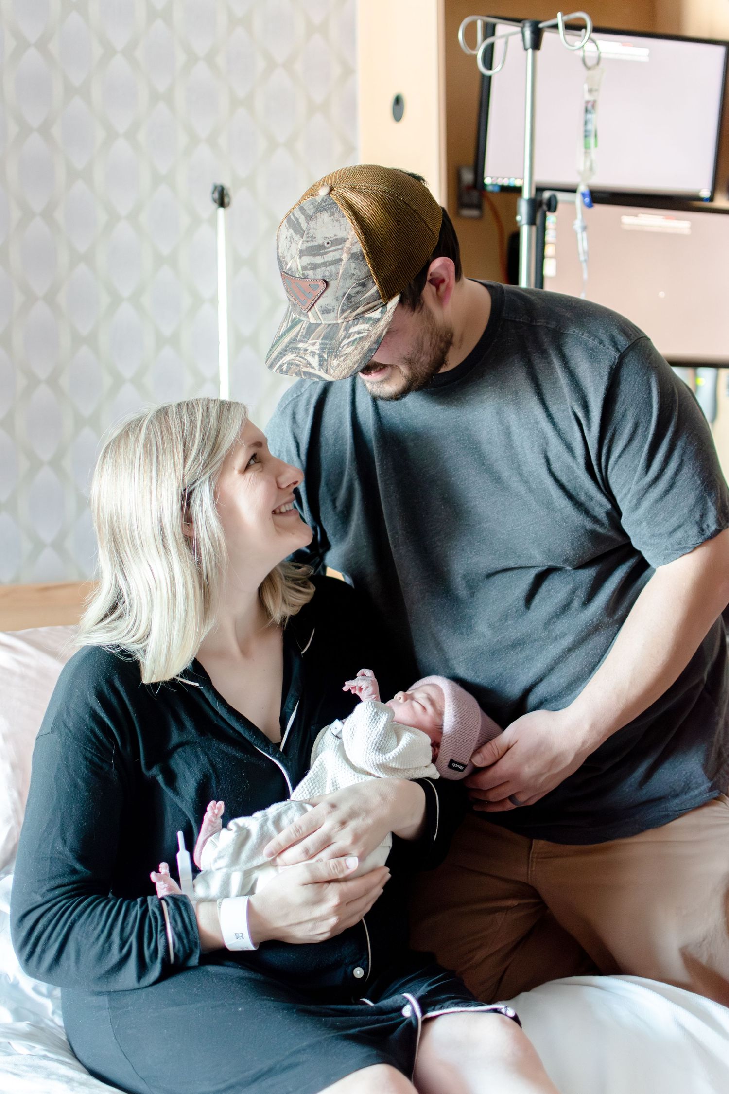 A family sharing tender moments with their newborn in a hospital room.