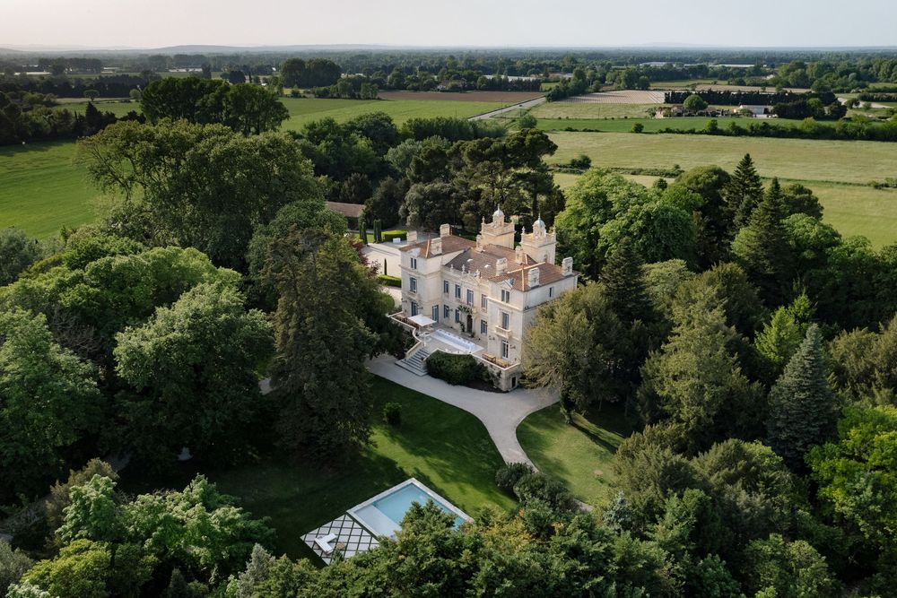 Aerial panoramic view of a grand estate surrounded by lush green countryside.