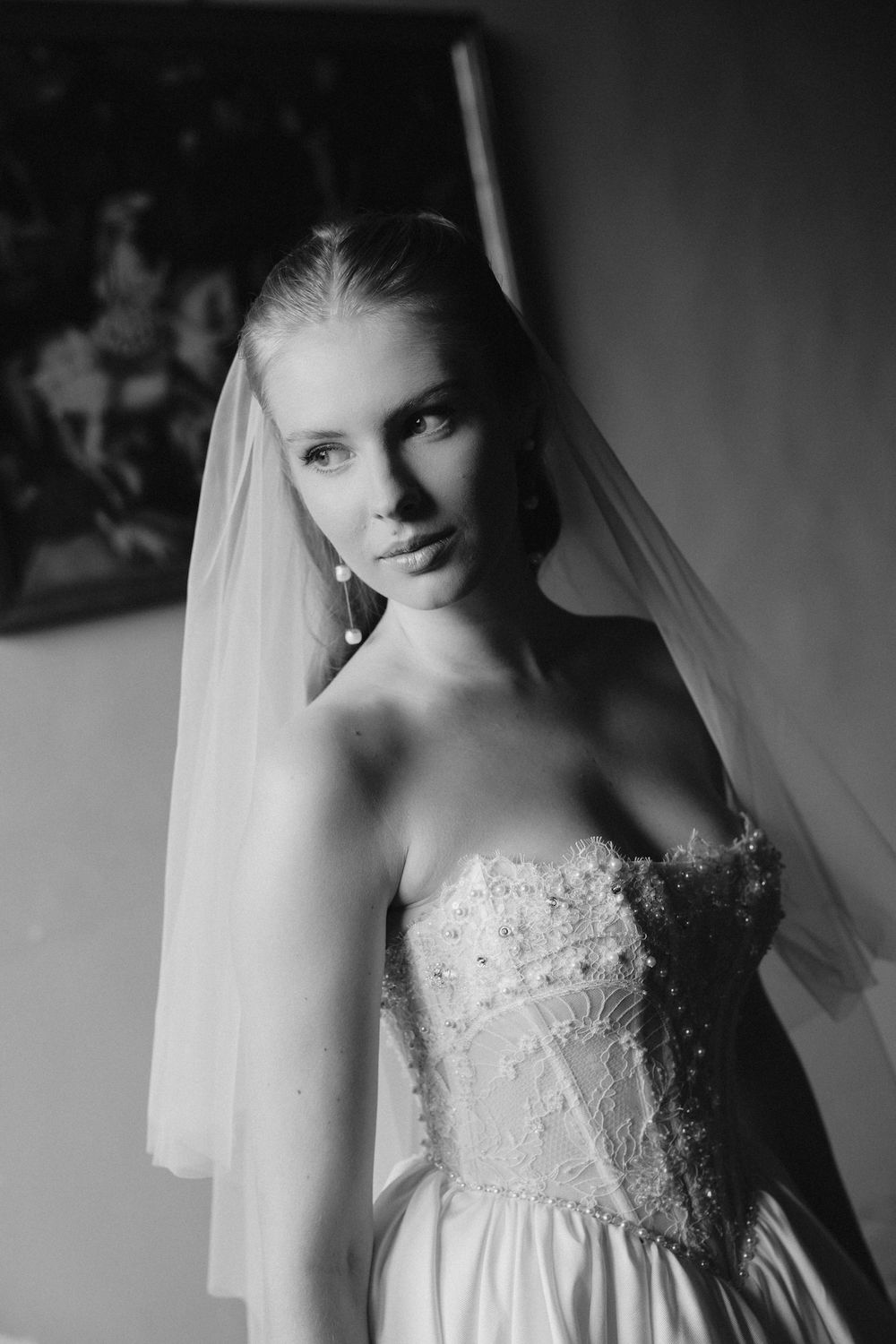 Dramatic black and white bridal portrait highlighting lace details and veil.