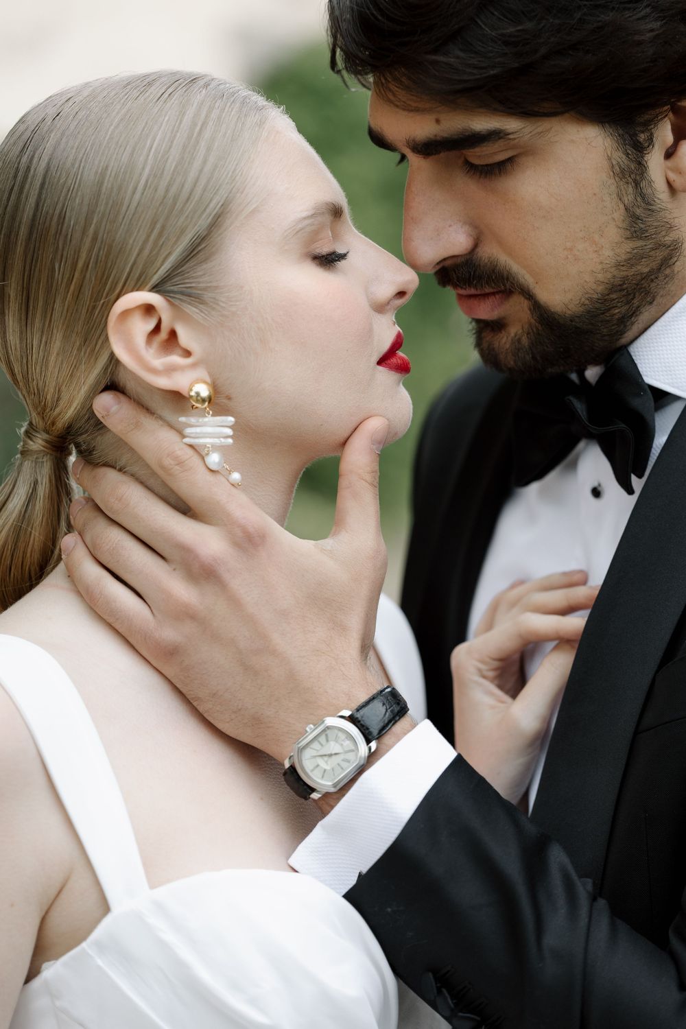 Intimate portrait of a romantic couple in formal attire sharing a tender moment.