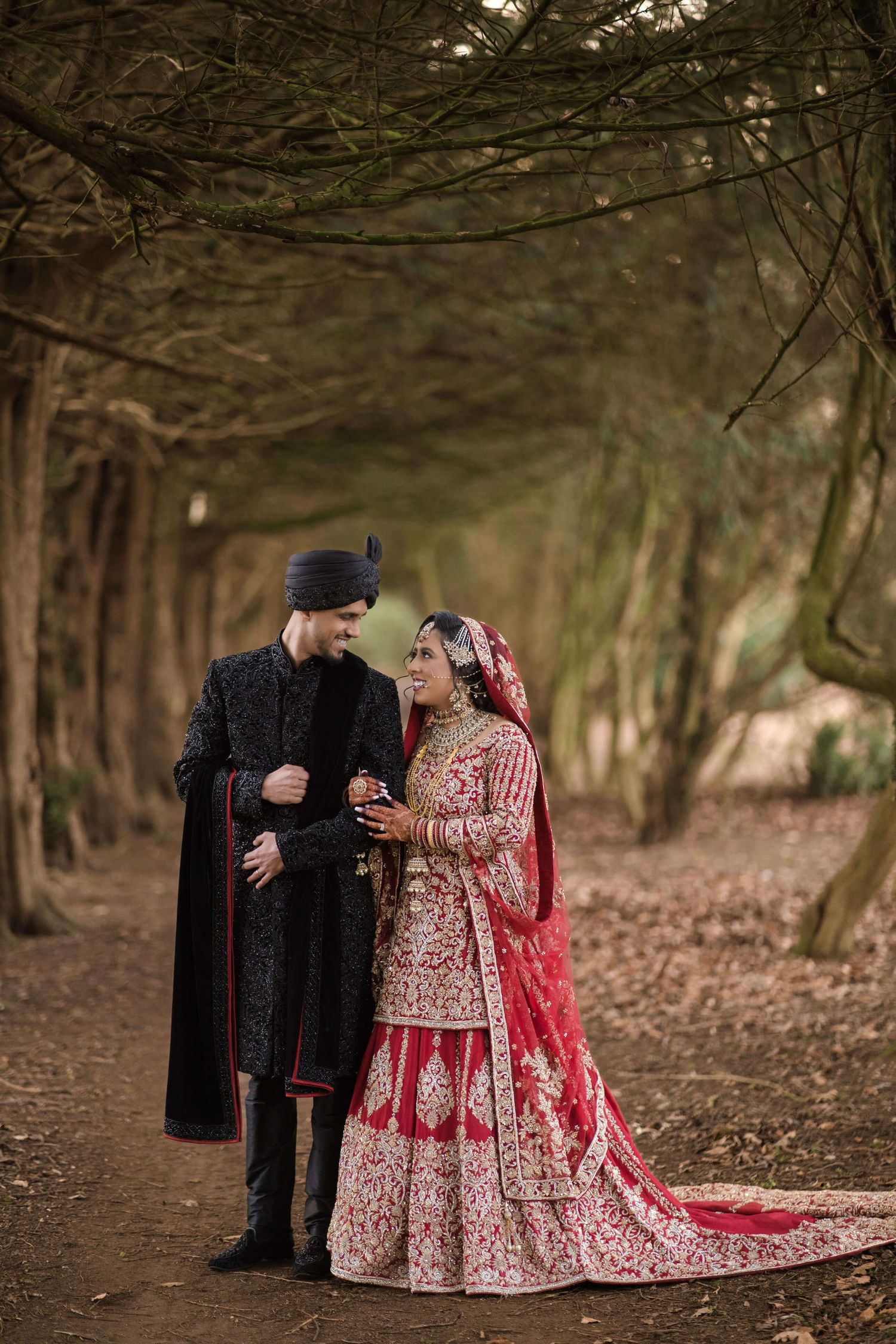 Wedded Couple holding arms and posing for a picture in the woodlands.