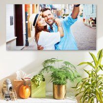 Casual street photography displayed on wall above decorative potted plants and home decor items.