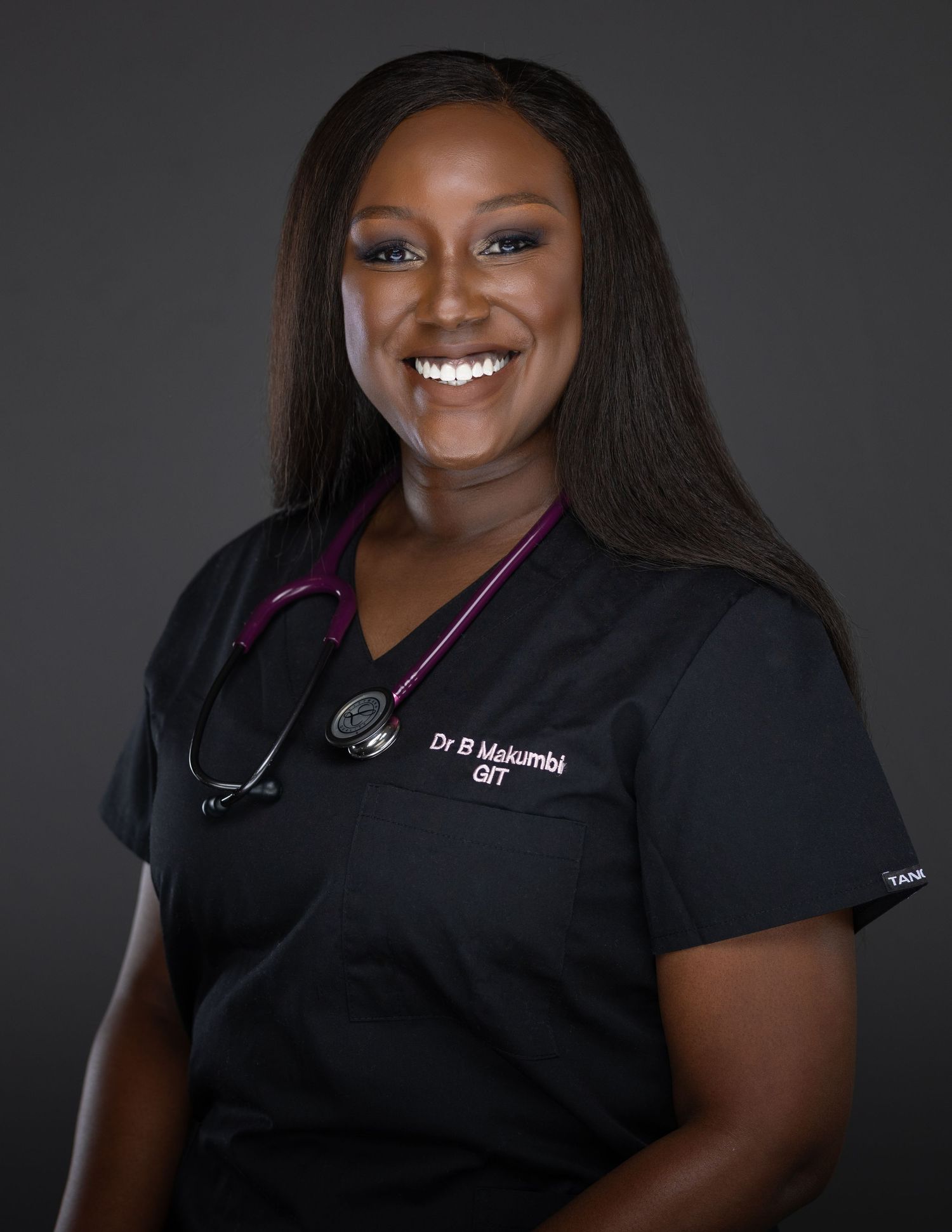 Healthcare professional in black scrubs poses for a series of professional headshots against dark background.