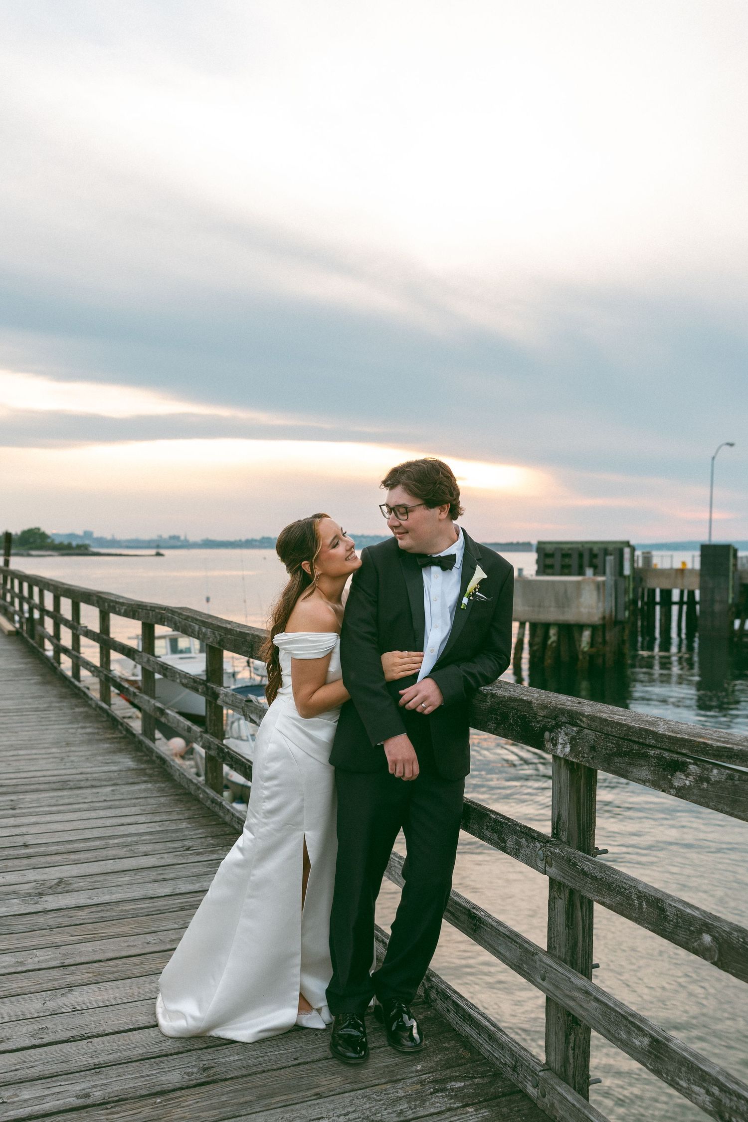 Romantic sunset wedding photos of couple sharing intimate moments by the waterfront.