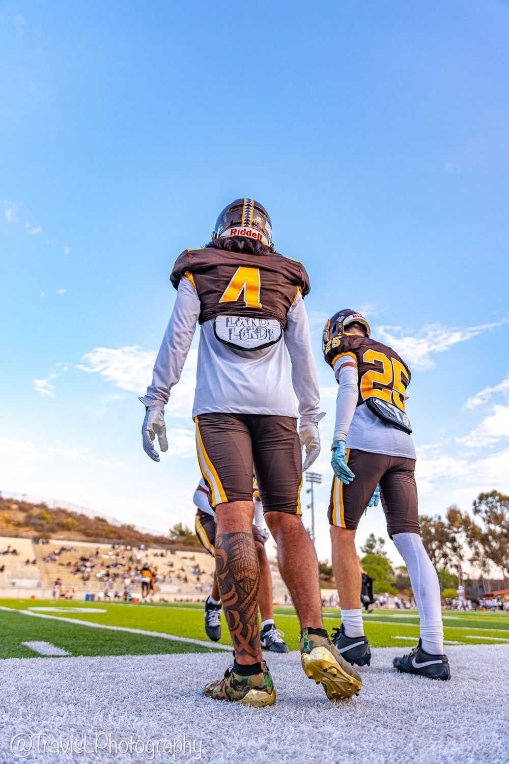 Low angle view of football players' legs and cleats on white field markings.