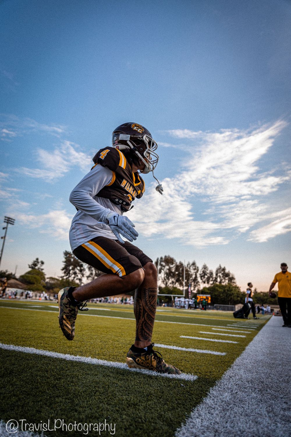 Football player performs diving catch sequence on field during daytime practice.