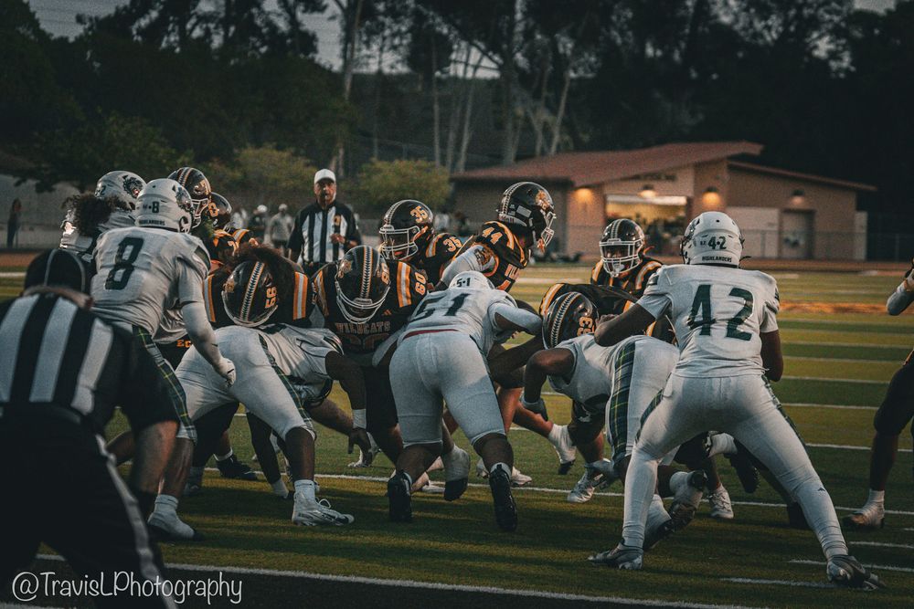 Football players engage in gameplay action during evening game.