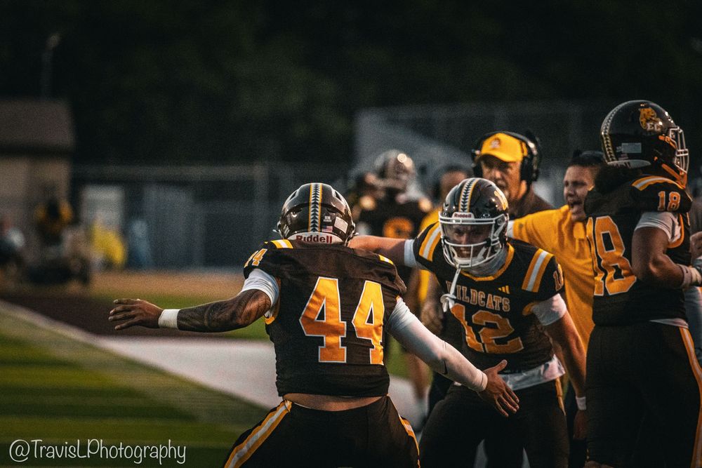 Football teams compete during nighttime game under stadium lights.