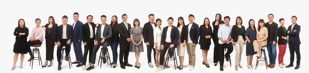 A diverse group of people standing together in professional business attire arranged in studio-style rows.