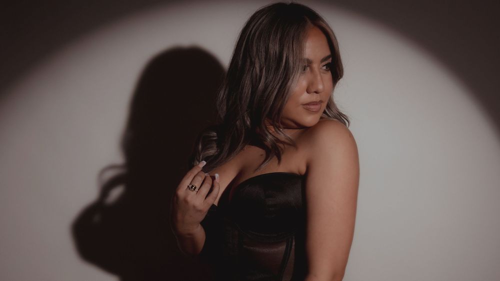 Dramatic studio portrait with spotlight effect creating bold shadows.
