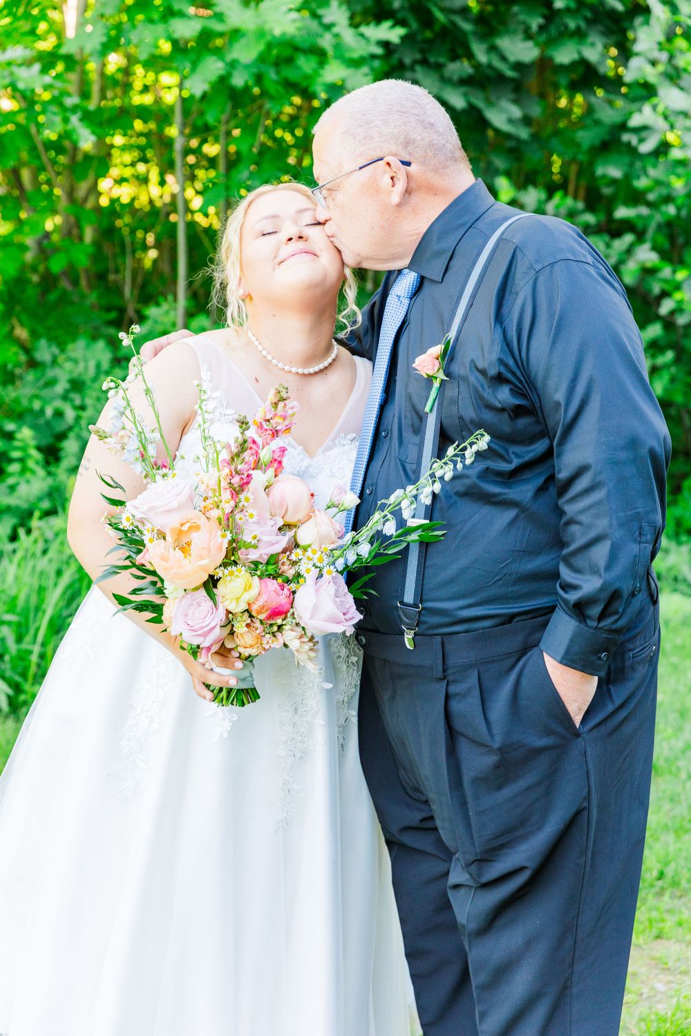 A romantic wedding moment captured in a garden setting with a beautiful floral bouquet.