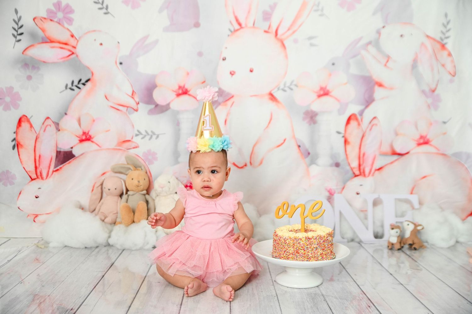 Pink and white bunny-themed birthday setup with cake and decorations for a special celebration.