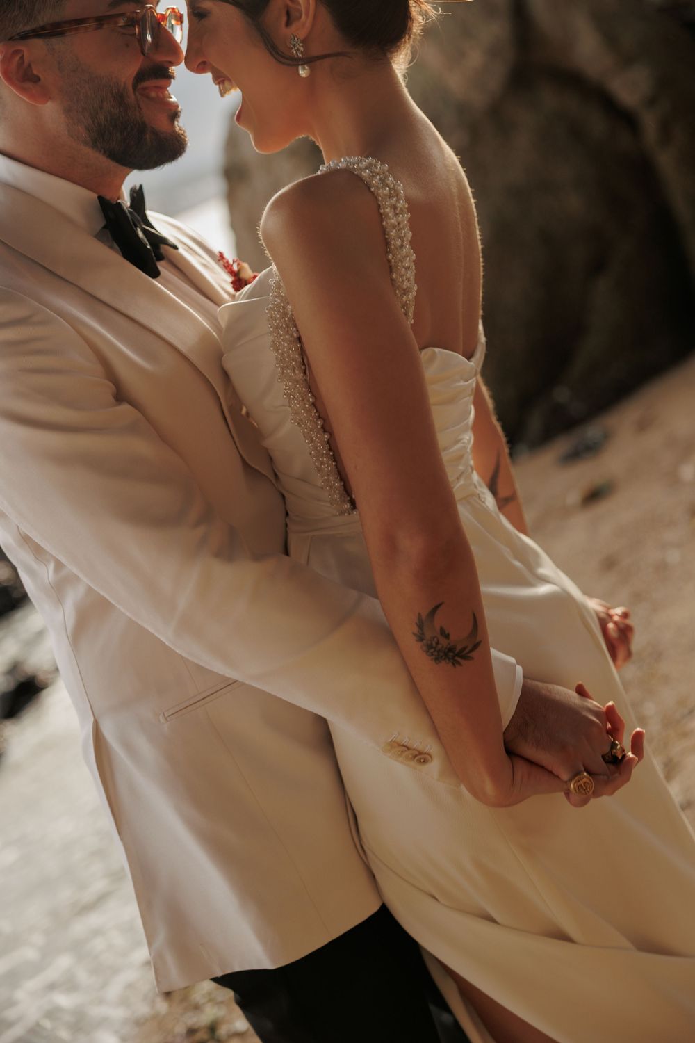 Intimate moment between newlyweds with bride wearing lace detailed white wedding dress.