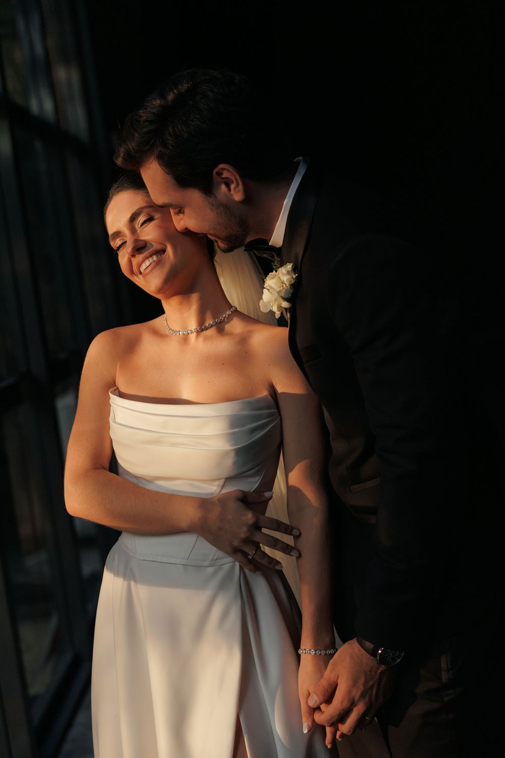 An elegant wedding photo capturing a romantic moment in dramatic lighting.