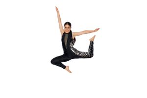 Dancer in black attire performs a graceful leap against white background.
