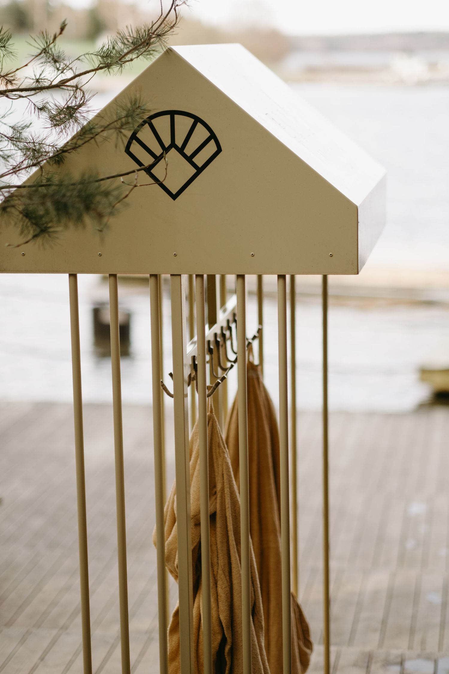 yellow bathrobes having from a hanger at Ellery Beach house while being captured by brand photographer in Stockholm
