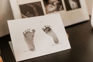 Row of cards with baby footprints displayed on dark surface.
