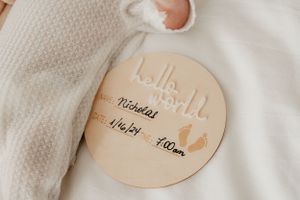 Wooden circular milestone marker for baby with measurement details.