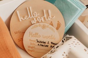 Clay or ceramic discs with handwritten messages in soft peach tones.