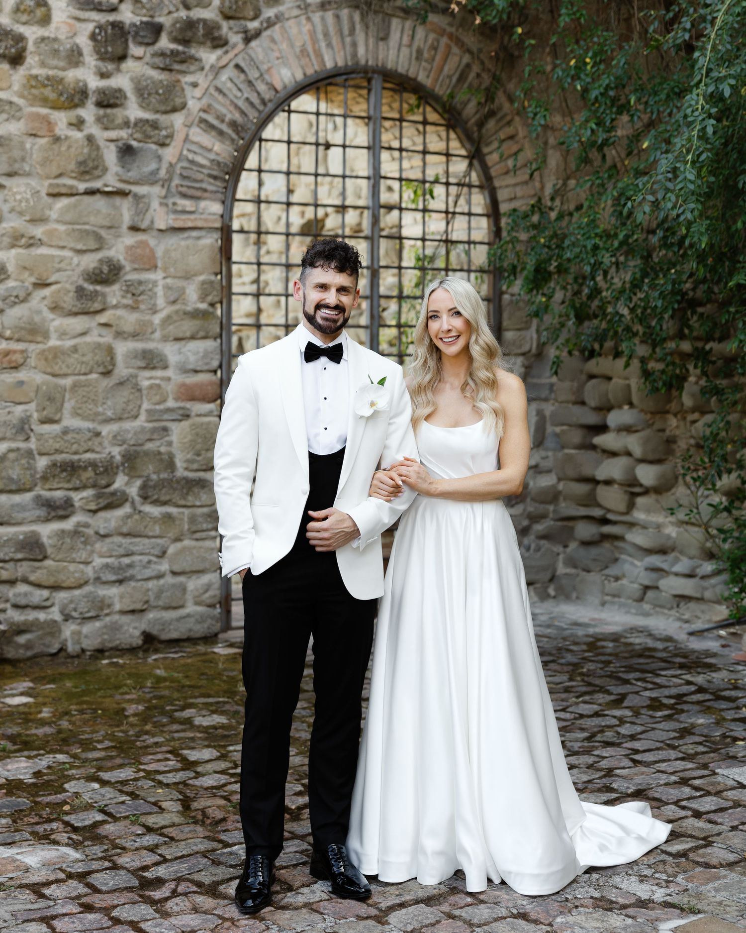 Wedding couple holding hands while walking through an elegant arched colonnade during a photoshoot in Paris, France.