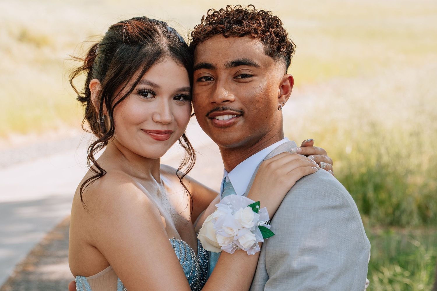 Romantic sunset engagement photos of couple in formal attire in golden field.