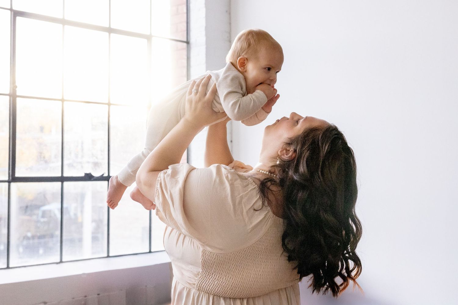 A tender moment between in soft natural window light wearing delicate floral patterns.