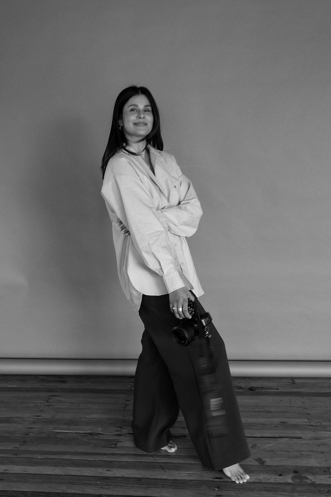 Black and white fashion portrait featuring oversized white shirt and wide-leg pants.